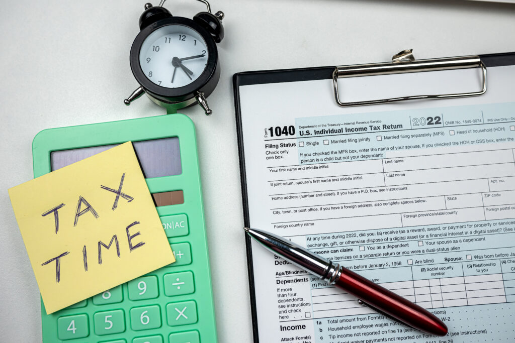 2022 blank us 1040 tax form with clock memo tax time and pen on office desk, paperwork. Accounting concept